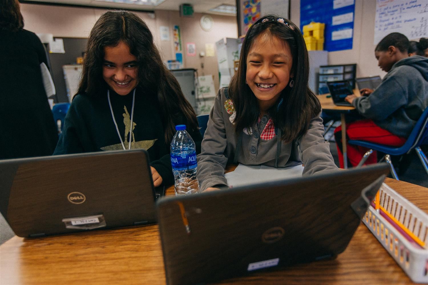 Two students laughing on computer 