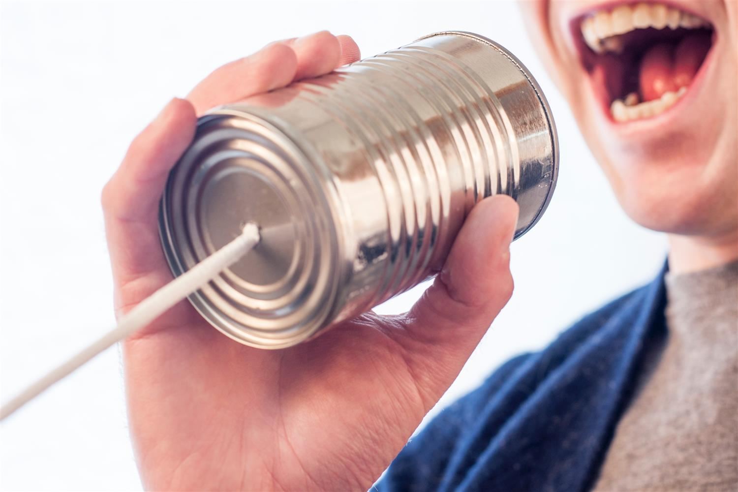 Kid talking on a can phone.