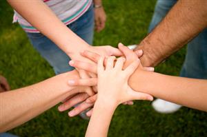 Hands stacked in a group circle 