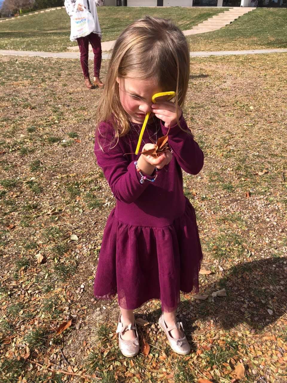 Girl looking at leaves with magnifier 