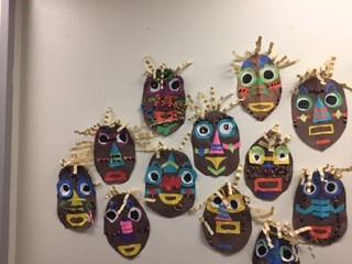 Student-made masks on a wall 
