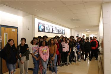 Students standing in front of End Racism banner