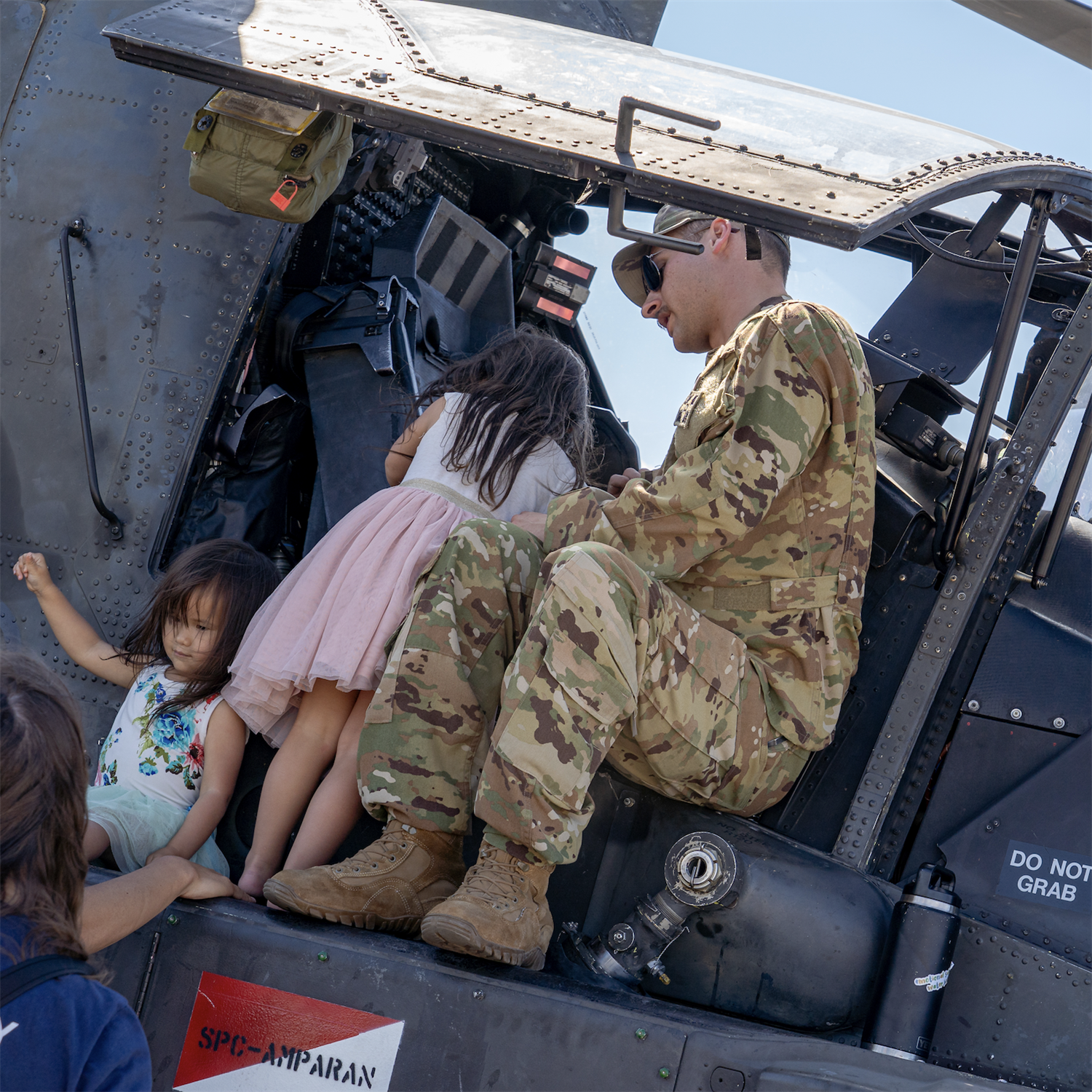 soldier with young children inside military helicopter