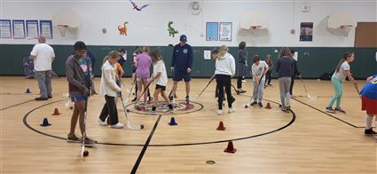  students playing hockey in the gym