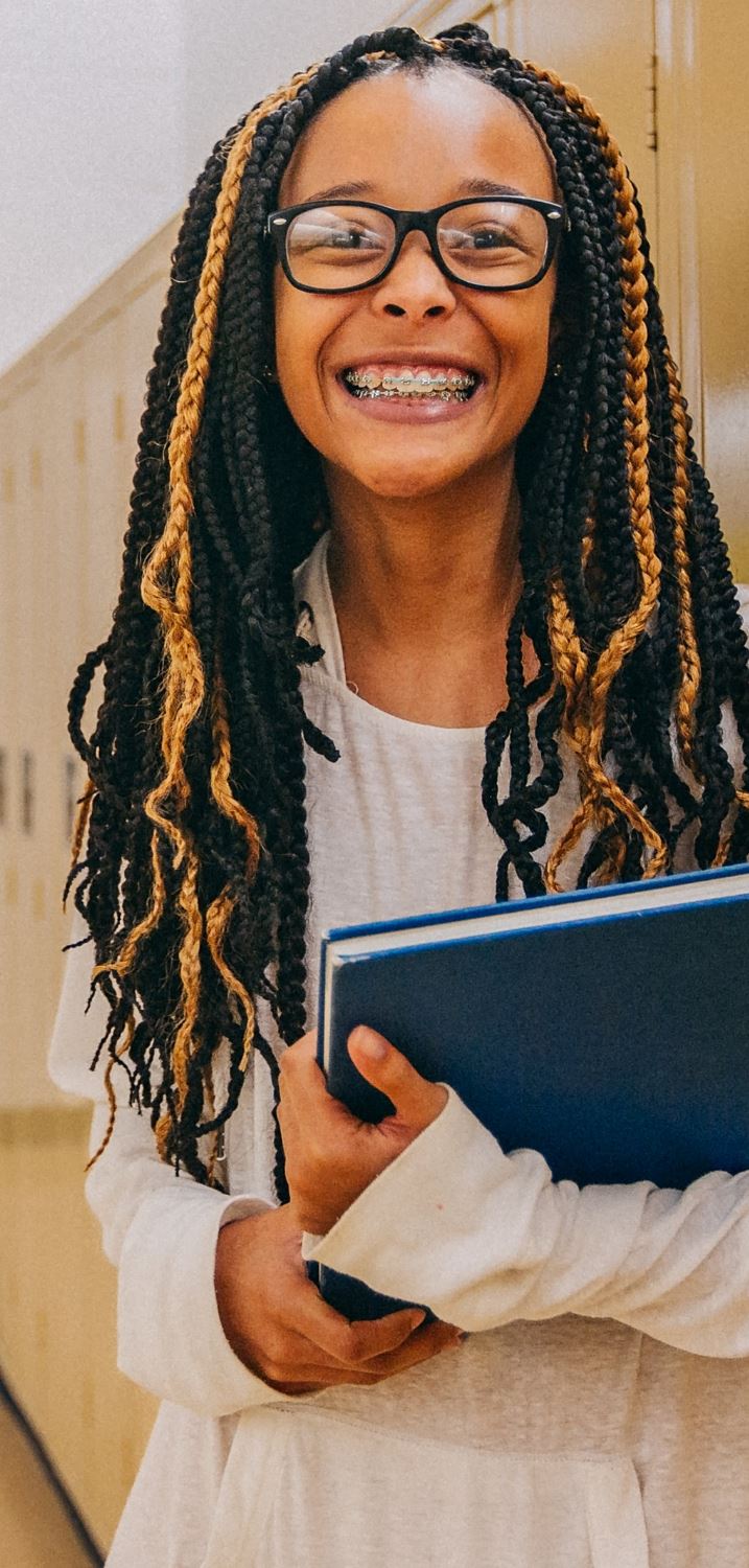 student in hallway holding book student in hallway holding book
