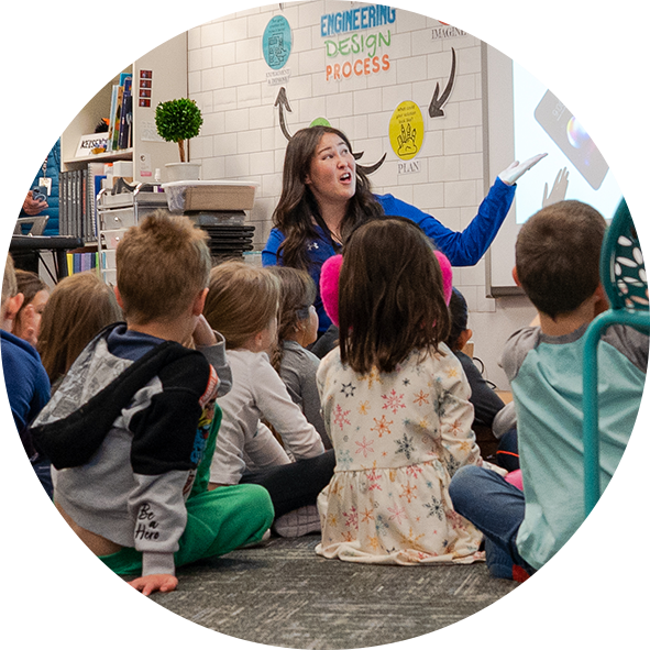teacher leading classroom with students seated on floor