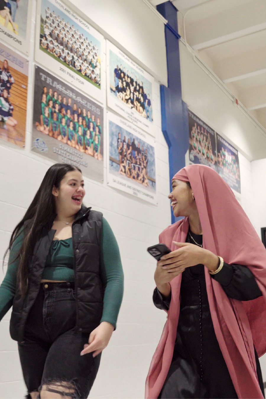 high schools students laughing with each other in the hallway